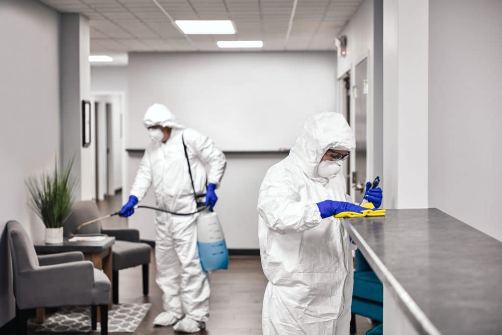 Disinfection cleaning services in Calgary with technicians in full PPE sanitizing a commercial office